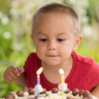 young boy blowing out candles