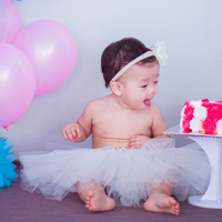 baby choosing cake over balloons