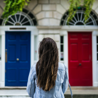 woman choosing between a red door and a blue door