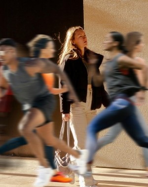 woman strolling amid many runners