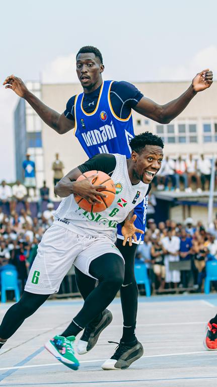 basketball player trying to dodge a very tall player 
