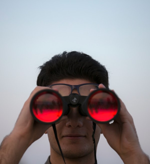man looking through binoculars