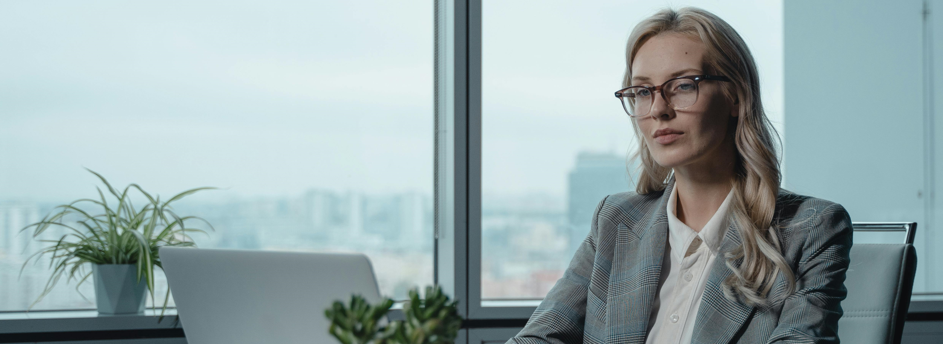 business woman in gray suit at her desktop computer