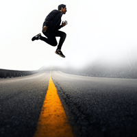 man jumping over road